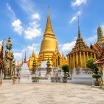 Chedi dorato e statue di guardiani Yak nel tempio Wat Phra Kaew presso il Grande Palazzo Reale di Bangkok