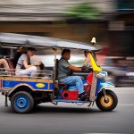 Tuk tuk a Bangkok in movimento con passeggeri per le strade della città