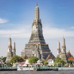 La maestosa pagoda centrale del tempio Wat Arun a Bangkok vista dal fiume Chao Phraya